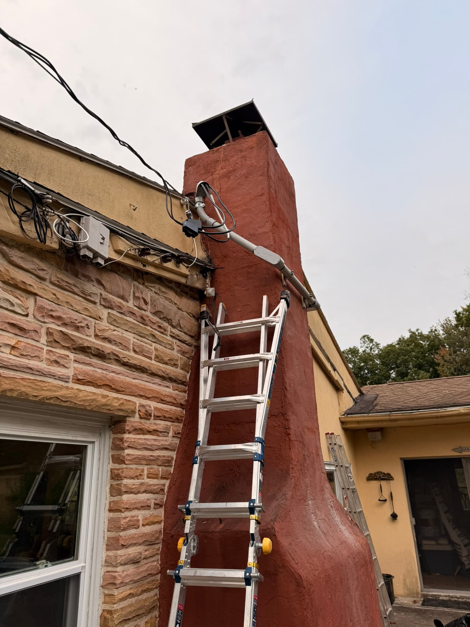 This project was a doozy. After consulting with the inspector and local utility company, this was the best option for running the new service around the chimney.